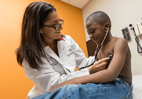 Doctor with stethoscope examining young patient